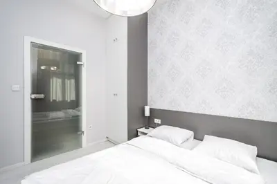 a bedroom with a white bed and a mirror at RentPlanet - Apartament Wieliczka in Wieliczka