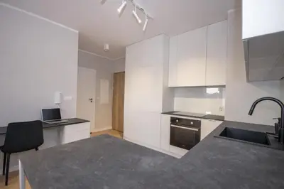 a kitchen with white cabinets and a sink at InPoint Modern Apartment Lema 17-Tauron Arena & Free Parking Self Check-in in Kraków