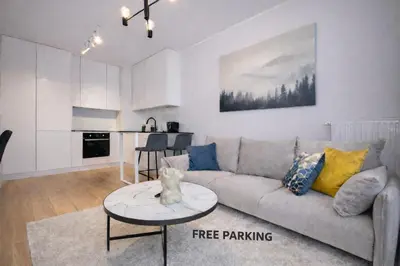 a living room with a couch and a table at InPoint Modern Apartment Lema 17-Tauron Arena & Free Parking Self Check-in in Kraków