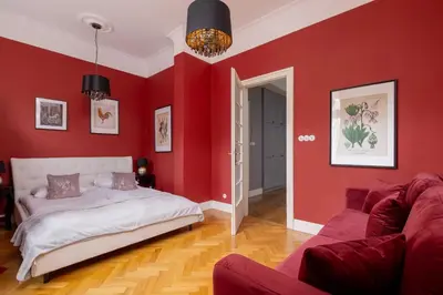 a red bedroom with a bed and a couch at Luxury Apartment with Two Bedrooms and Balcony by Renters Prestige in Kraków