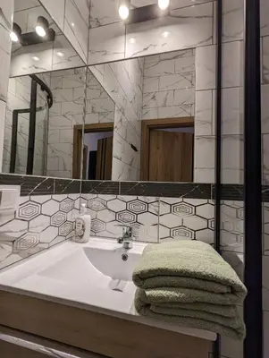 a bathroom with a sink and a large mirror at Apartment A1 in Downtown of Krakow in Kraków