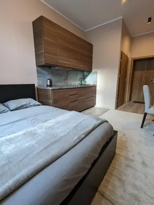 a bedroom with a large bed and a chair at Apartment A1 in Downtown of Krakow in Kraków