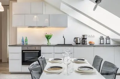 a white kitchen with a table and chairs at MODERN & NEW place next to Wawel Castle & Vistula in Kraków