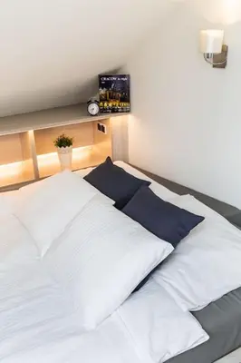 a bed with white sheets and blue pillows on it at MODERN & NEW place next to Wawel Castle & Vistula in Kraków