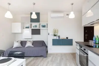 a living room with a couch and a kitchen at MODERN & NEW place next to Wawel Castle & Vistula in Kraków