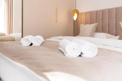 a pile of towels sitting on top of a bed at Glossy Apart G29 in Kraków