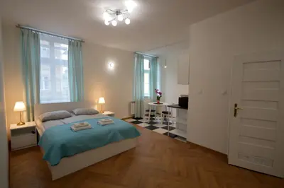 a bedroom with a bed with a blue blanket at Royal Castle Apartments in Kraków