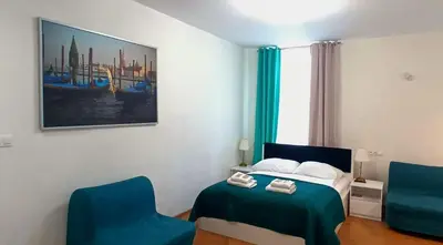 a bedroom with a bed and two blue chairs at Royal Castle Apartments in Kraków