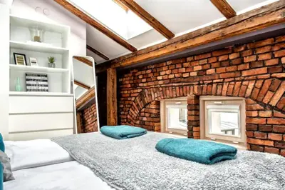 a bedroom with a brick wall and a bed with pillows at Exclusive loft with Sauna, AC and 3 bathrooms in Kraków