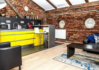 a kitchen with a yellow counter and a brick wall at Exclusive loft with Sauna, AC and 3 bathrooms in Kraków