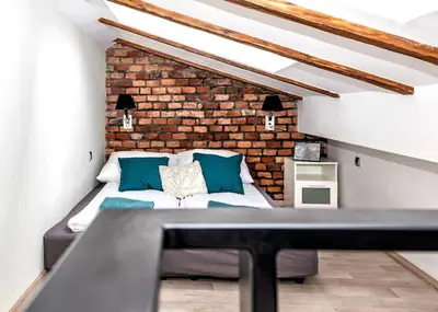 a bed in a room with a brick wall at Exclusive loft with Sauna, AC and 3 bathrooms in Kraków
