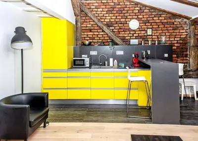 a yellow kitchen with a counter and a sink at Exclusive loft with Sauna, AC and 3 bathrooms in Kraków
