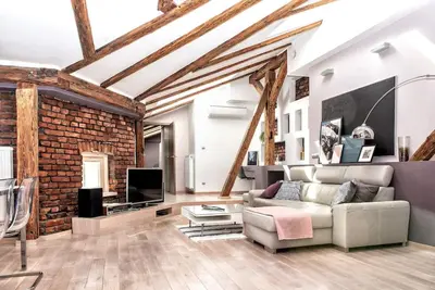 a living room with a couch and a brick wall at Exclusive loft with Sauna, AC and 3 bathrooms in Kraków