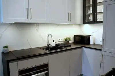 a kitchen with white cabinets and a sink at Exclusive, unique apartment, 2 bathrooms, 105sqm in Kraków