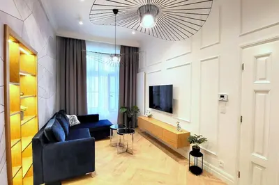 a living room with a blue couch and a television at Exclusive, unique apartment, 2 bathrooms, 105sqm in Kraków