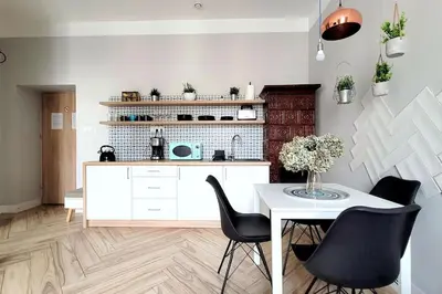 a kitchen with a white table and black chairs at Wild & Huge comfy apartment 5 min to Main Square in Kraków