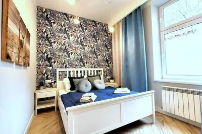 a small bedroom with a bed with a blue blanket at Wild & Huge comfy apartment 5 min to Main Square in Kraków
