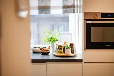 a kitchen counter with a table with food and a window at Florencja Moxy TE&AM Stare Miasto Dworzec 3 min Parking GRATIS in Kraków