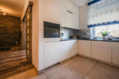 a kitchen with white cabinets and a window at Florencja Moxy TE&AM Stare Miasto Dworzec 3 min Parking GRATIS in Kraków
