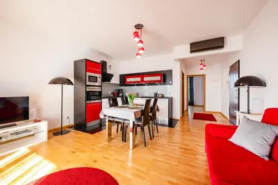 a living room with a red couch and a table at Rimini Moxy TE&AM Old Town Free Parking Dworzec 5 min in Kraków