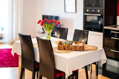 a dining room with a table and chairs with a vase of flowers at Rimini Moxy TE&AM Old Town Free Parking Dworzec 5 min in Kraków