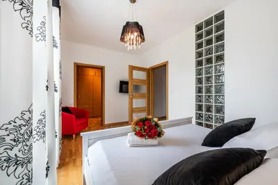 a bedroom with a white bed and a red chair at Rimini Moxy TE&AM Old Town Free Parking Dworzec 5 min in Kraków
