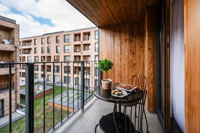 a balcony with a table and chairs and a building at Rimini Moxy TE&AM Old Town Free Parking Dworzec 5 min in Kraków
