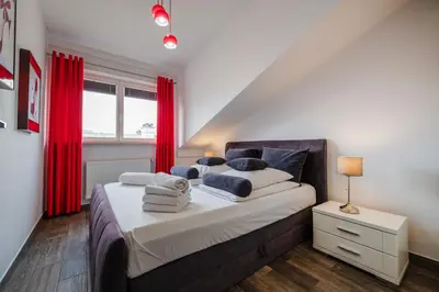 a bedroom with a large bed with red curtains at Perugia Moxy TE&AM Old Town Parking gratis in Kraków