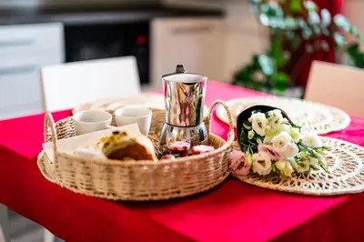 a red table with a basket of food and flowers at Perugia Moxy TE&AM Old Town Parking gratis in Kraków