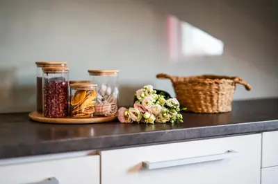 a counter with jars of food and flowers on it at Perugia Moxy TE&AM Old Town Parking gratis in Kraków