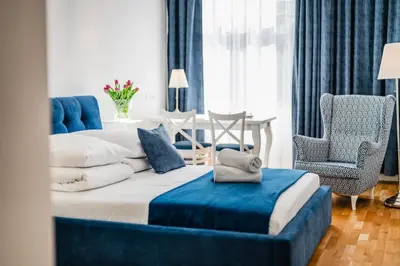 a bedroom with a large bed and a blue chair at Wenecja Moxy TE&AM Stare Miasto Dworzec 3 min Parking GRATIS in Kraków