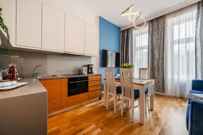 a kitchen with white cabinets and a table and chairs at Wenecja Moxy TE&AM Stare Miasto Dworzec 3 min Parking GRATIS in Kraków