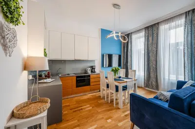 a kitchen and a living room with a blue couch at Wenecja Moxy TE&AM Stare Miasto Dworzec 3 min Parking GRATIS in Kraków
