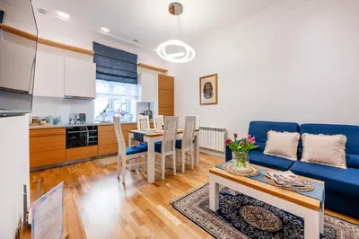 a living room with a blue couch and a table at Wenecja Moxy TE&AM Stare Miasto Dworzec 3 min Parking GRATIS in Kraków