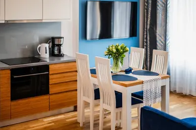 a kitchen with a table and chairs and a kitchen with blue walls at Wenecja Moxy TE&AM Stare Miasto Dworzec 3 min Parking GRATIS in Kraków