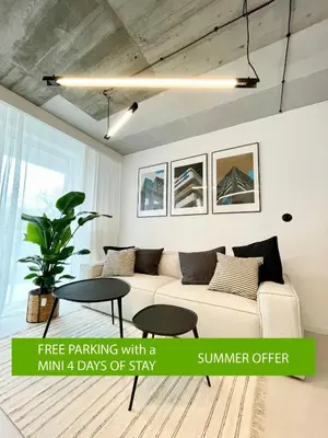 a living room with a couch and a table at Premium Loft Apartments-City Center Parking by Urban Escape in Kraków