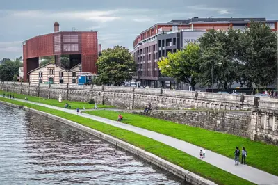 people walking along a path next to a river at Premium Loft Apartments-City Center Parking by Urban Escape in Kraków