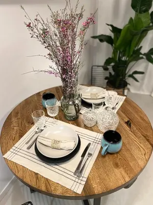 a wooden table with plates and glasses and a vase of flowers at Premium Loft Apartments-City Center Parking by Urban Escape in Kraków