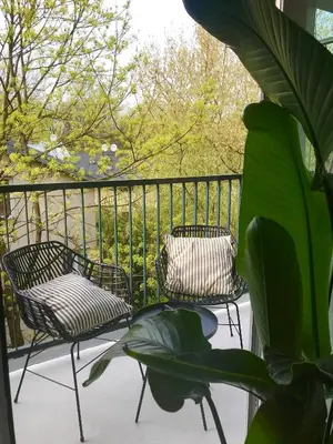 two chairs and a plant on a balcony at Premium Loft Apartments-City Center Parking by Urban Escape in Kraków