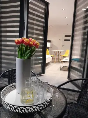 a glass table with a vase of flowers on it at Viva Apartments in Oświęcim