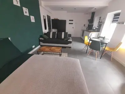 a room with a bed and a living room with a couch at Viva Apartments in Oświęcim