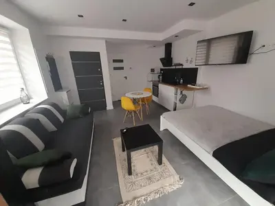 a bedroom with a bed and a couch and a table at Viva Apartments in Oświęcim