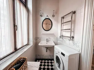 a bathroom with a washing machine and a sink at Once Upon a Time in Cracow - Old Town Apartment in Kraków