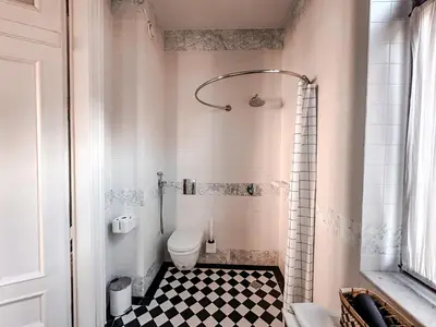 a bathroom with a toilet and a black and white checkered floor at Once Upon a Time in Cracow - Old Town Apartment in Kraków