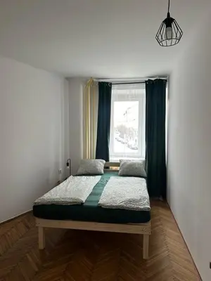 a bedroom with a bed in a room with a window at Rooms in City Center Kraków in Kraków