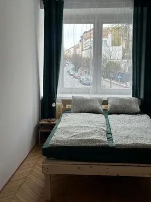 a bed in a room with a large window at Rooms in City Center Kraków in Kraków