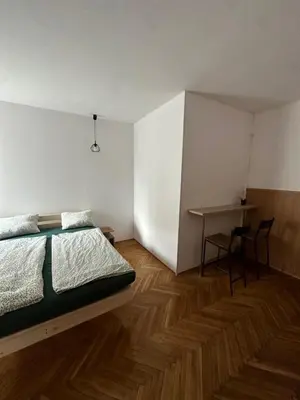 a bedroom with a bed and a desk in it at Rooms in City Center Kraków in Kraków