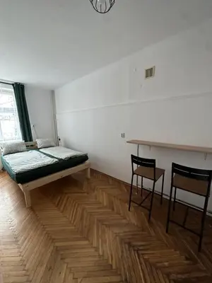 a room with a bed and a table and chairs at Rooms in City Center Kraków in Kraków
