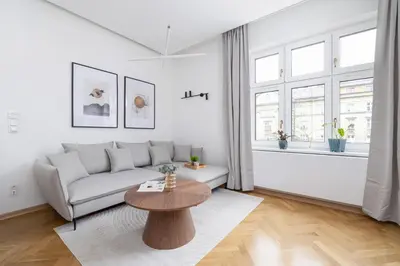a white living room with a couch and a table at Słowackiego Elegant Apartment Kraków by Noclegi Renters in Kraków