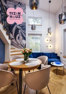 a living room with a table and a blue couch at Tyzenhauz Apartments Siemiradzkiego Street in Kraków